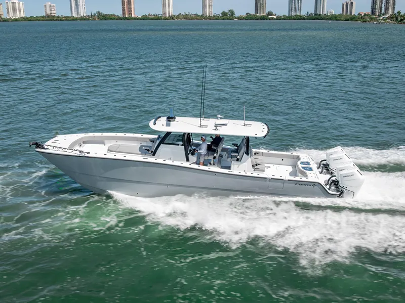 Slide: The Image of 2024 Freeman 43 boat cruising on open water with city skyline in background. - 15