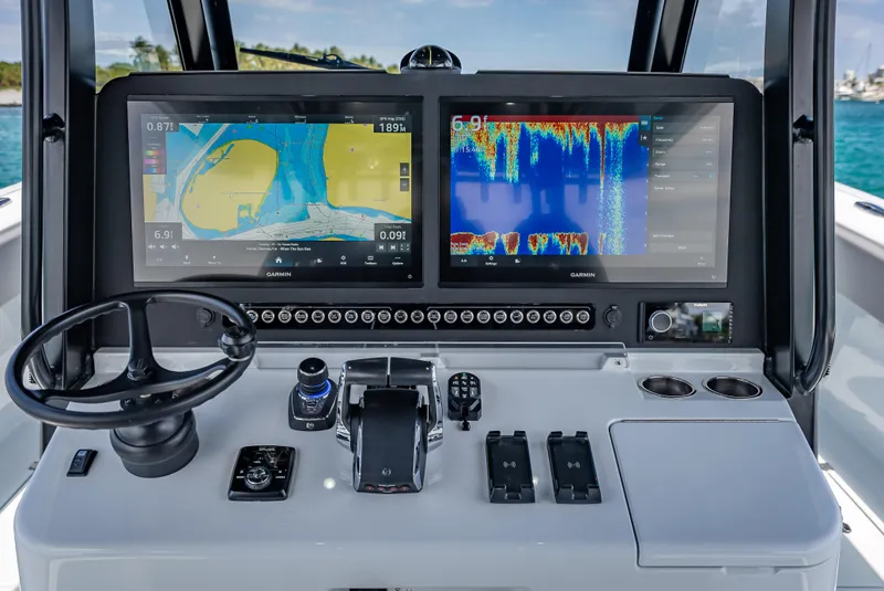 Slide: The Image of 2024 Freeman 43 boat dashboard with dual navigation screens and steering wheel. - 24