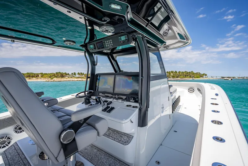 Slide: The Image of 2024 Freeman 43 boat cockpit with advanced navigation systems, cruising in clear blue waters. - 26