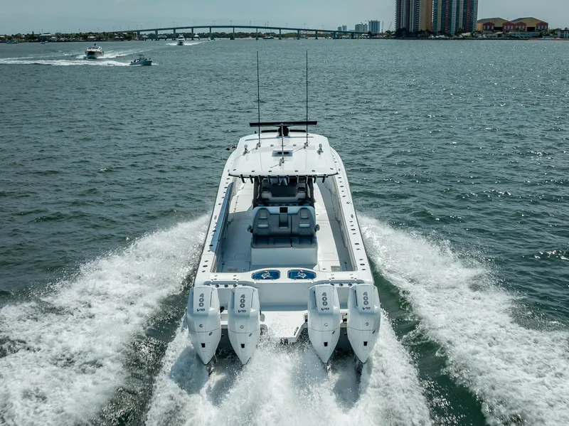 Slide: The Image of 2024 Freeman 43 boat cruising on open water with four engines, cityscape in background. - 3