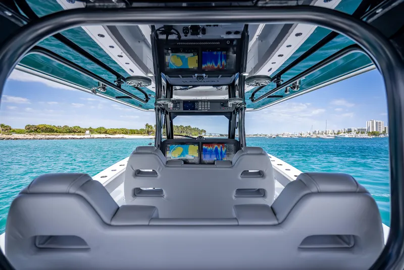 Slide: The Image of 2024 Freeman 43 boat interior with advanced navigation screens, overlooking clear blue waters. - 31
