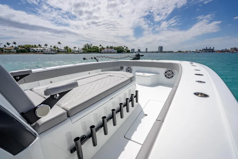 Slide: The Image of 2024 Freeman 43 boat on water, featuring spacious deck and rod holders under a clear sky. - 38