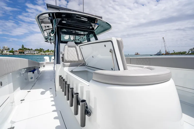 Slide: The Image of 2024 Freeman 43 boat with sleek design, rod holders, and spacious deck under a partly cloudy sky. - 41