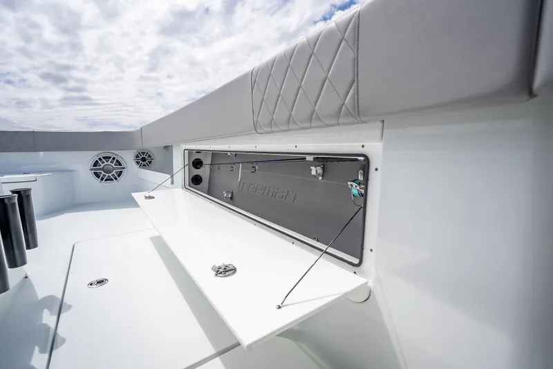 Slide: The Image of 2024 Freeman 43 boat interior with storage compartment and cushioned seating. - 48