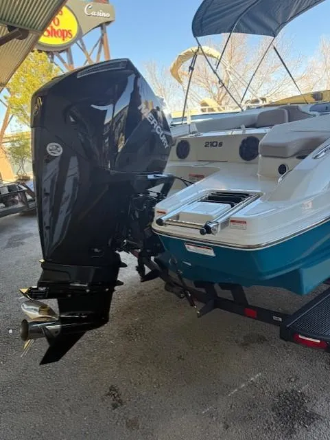 Slide: The Image of 2025 Tahoe 210 S boat with powerful outboard motor, parked under a canopy. - 9