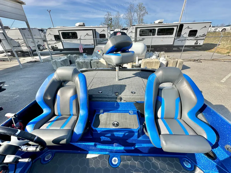 Slide: The Image of 2025 Nitro Z19 boat with open storage compartments in a parking lot. - 12