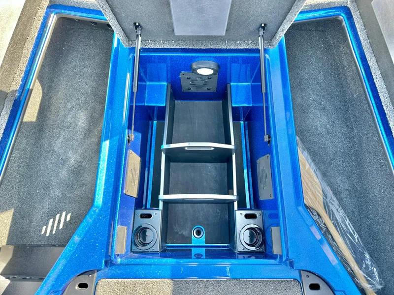 Slide: The Image of 2025 Nitro Z19 boat interior with blue and gray seats, parked near RVs. - 14