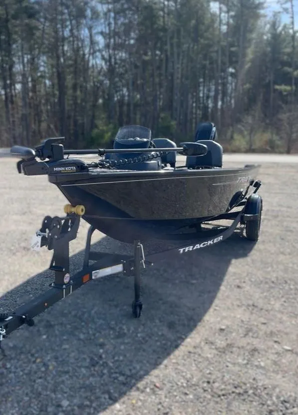 Slide: The Image of 2025 Tracker Super Guide V-16 SC boat on trailer, parked outdoors. - 2