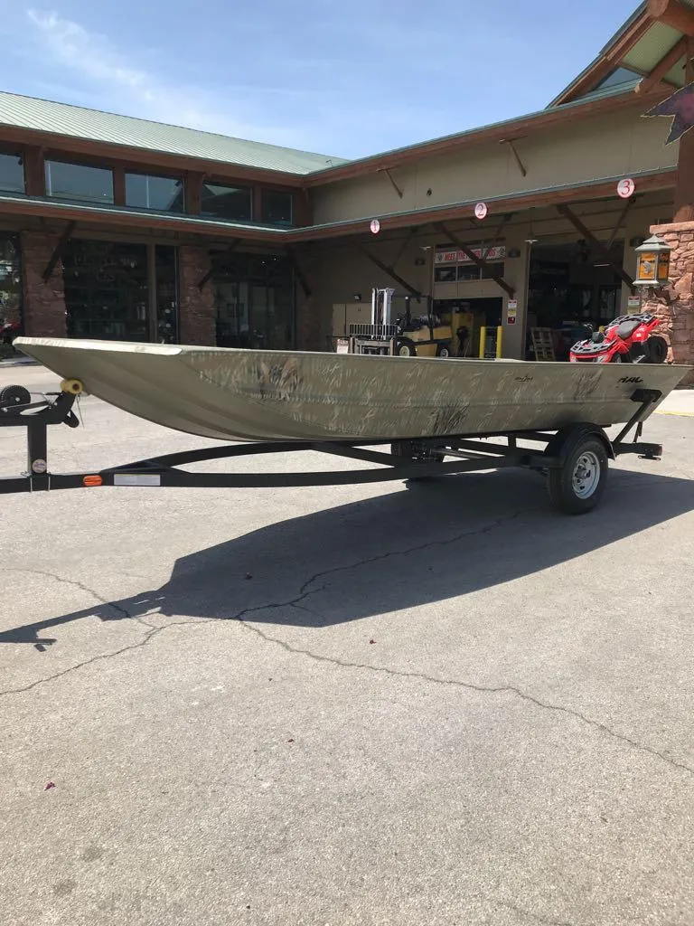 Slide: The Image of 2025 Tracker Grizzly 1754 Jon boat on trailer, parked outside a building. - 5