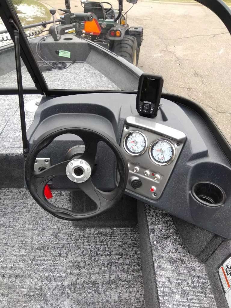 Slide: The Image of 2025 Tracker Pro Guide V-16 WT boat dashboard with steering wheel and gauges. - 3