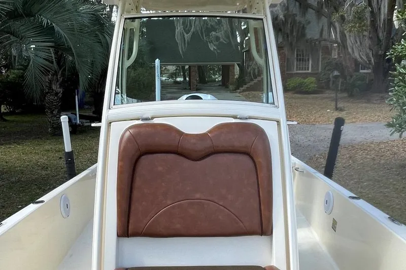 Slide: The Image of 2015 Scout 251 XS boat with brown seating, parked outdoors. - 10