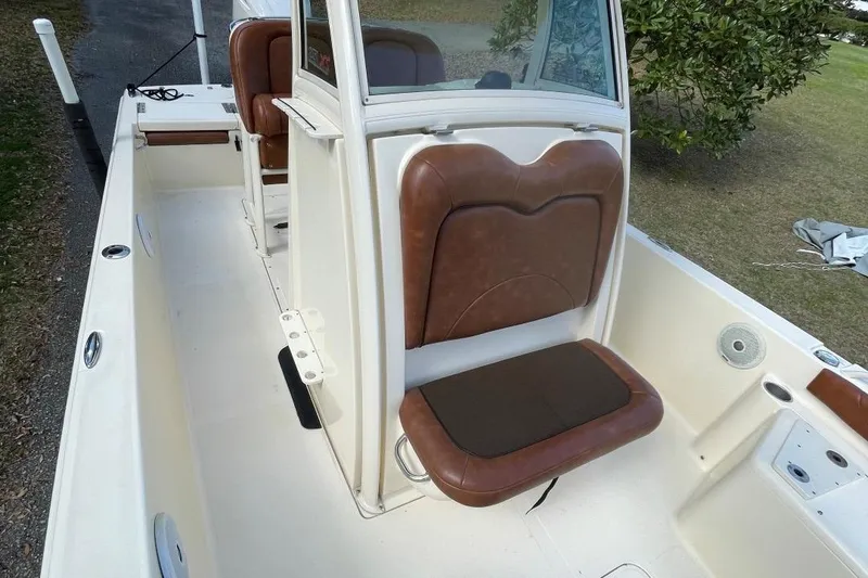 Slide: The Image of 2015 Scout 251 XS boat interior with brown cushioned seating and console. - 11