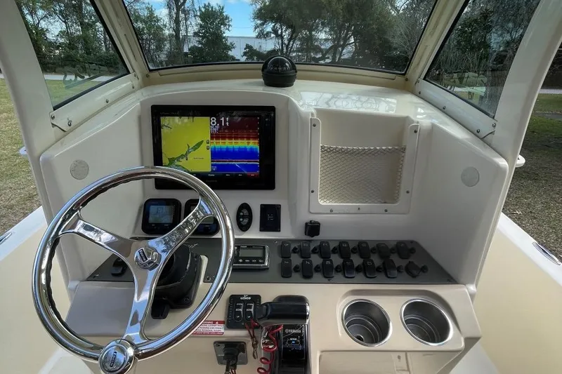 Slide: The Image of 2015 Scout 251 XS boat dashboard with steering wheel and navigation display. - 16
