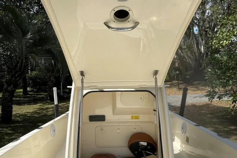 Slide: The Image of 2015 Scout 251 XS boat interior with open hatch, surrounded by trees. - 21