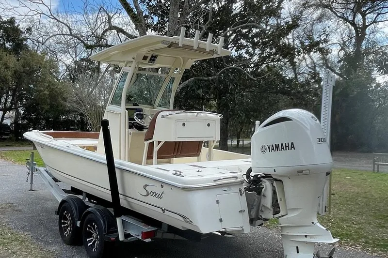 Slide: The Image of 2015 Scout 251 XS boat with Yamaha engine on a trailer, parked outdoors. - 4