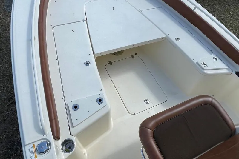 Slide: The Image of 2015 Scout 251 XS boat interior with white deck and brown seating. - 7