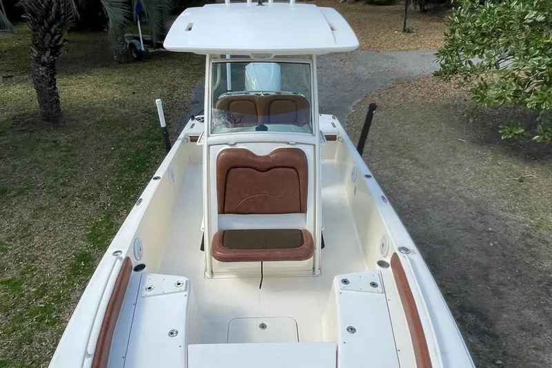 Slide: The Image of 2015 Scout 251 XS boat with brown seating, viewed from above, parked on grass. - 8