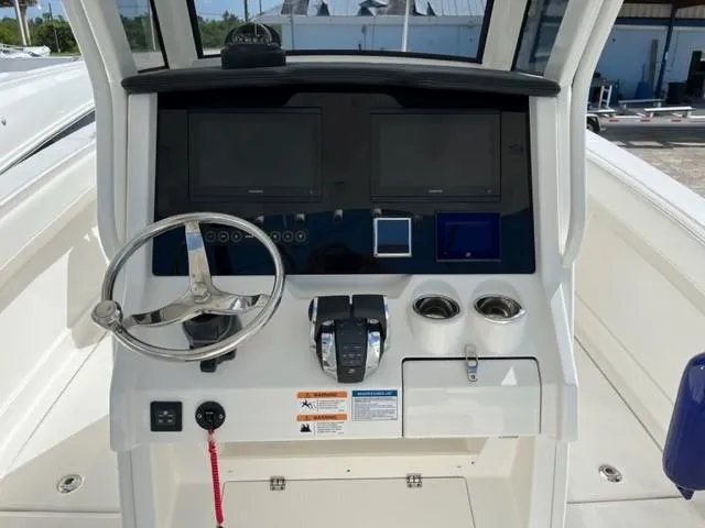Slide: The Image of 2025 World Cat 280 CC-X boat dashboard with dual screens and steering wheel. - 3