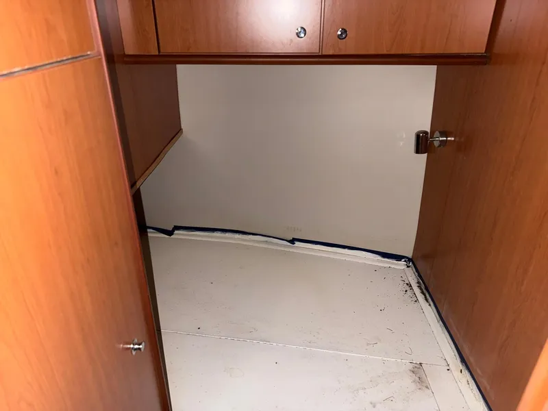 Slide: The Image of Empty storage space inside a 2008 Luhrs 35 Convertible boat with wooden cabinets. - 24