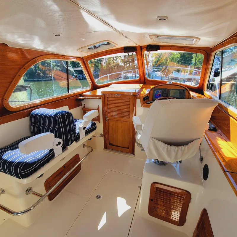 Slide: The Image of 1999 Hinckley Picnic Boat Classic interior with wood accents and striped seating. - 1