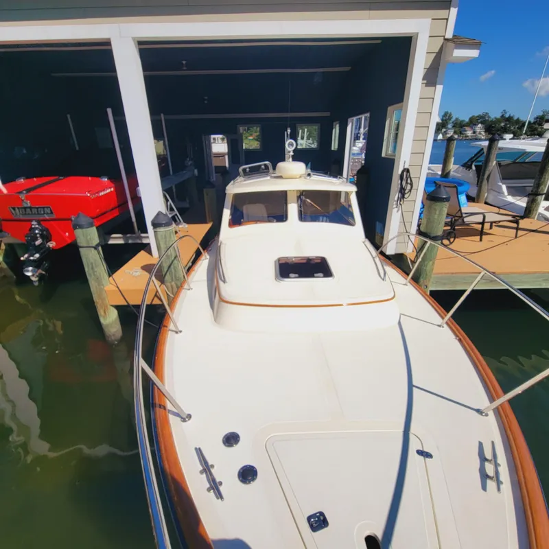 Slide: The Image of 1999 Hinckley Picnic Boat Classic docked in a marina, front view. - 10