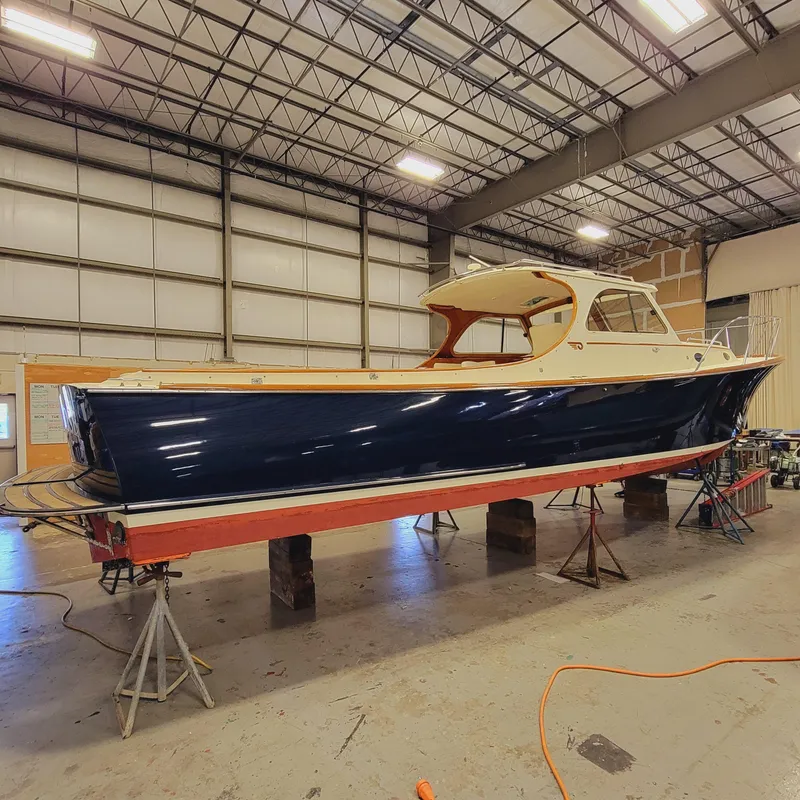 Slide: The Image of 1999 Hinckley Picnic Boat Classic in a warehouse, elevated on stands. - 11