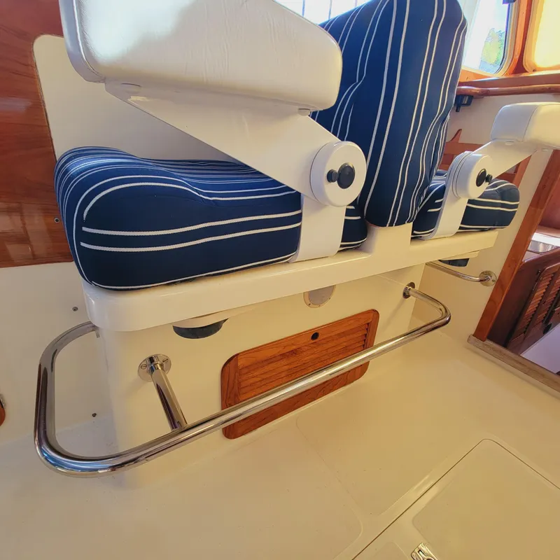 Slide: The Image of 1999 Hinckley Picnic Boat Classic interior with striped seating and wooden accents. - 13
