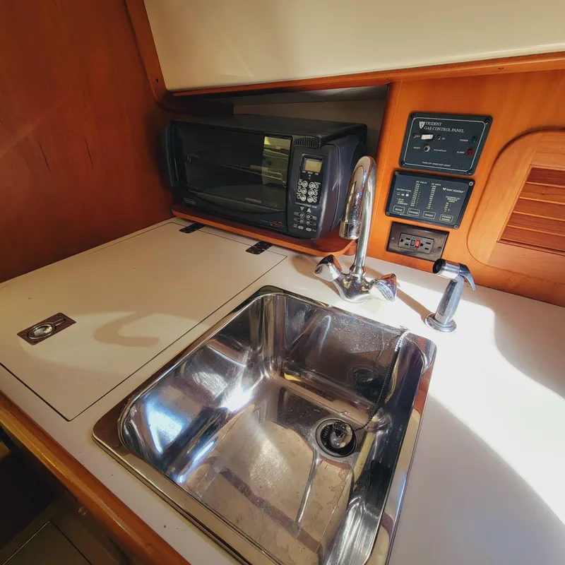 Slide: The Image of 1999 Hinckley Picnic Boat Classic galley with sink, microwave, and control panels. - 15