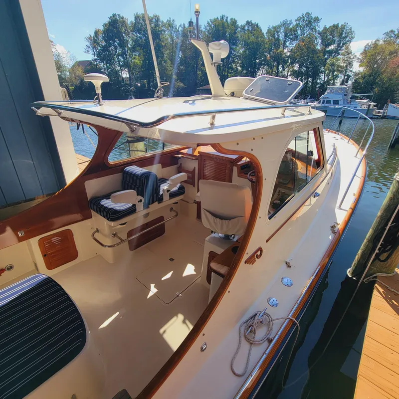 Slide: The Image of 1999 Hinckley Picnic Boat Classic docked, showcasing elegant design and spacious seating area. - 2