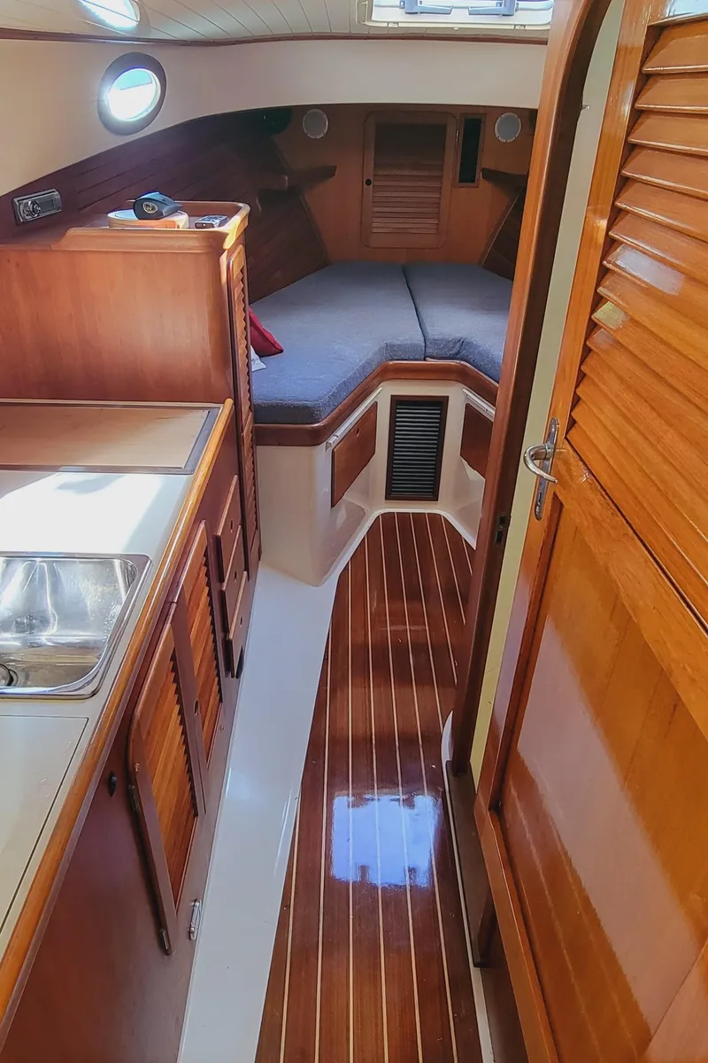 Slide: The Image of 1999 Hinckley Picnic Boat Classic interior with wood finish and cozy cabin space. - 37