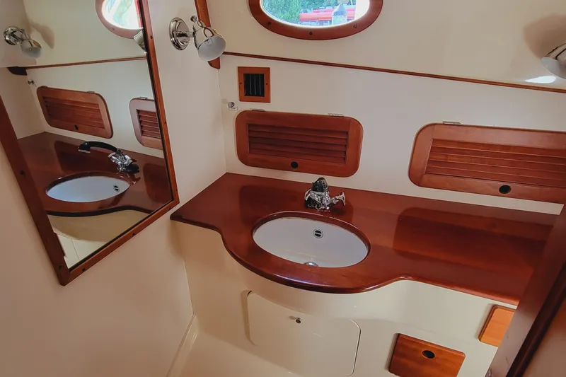 Slide: The Image of 1999 Hinckley Picnic Boat Classic bathroom with wooden vanity and mirror. - 39