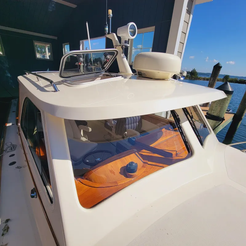 Slide: The Image of 1999 Hinckley Picnic Boat Classic docked, showcasing its sleek design and elegant cabin. - 41