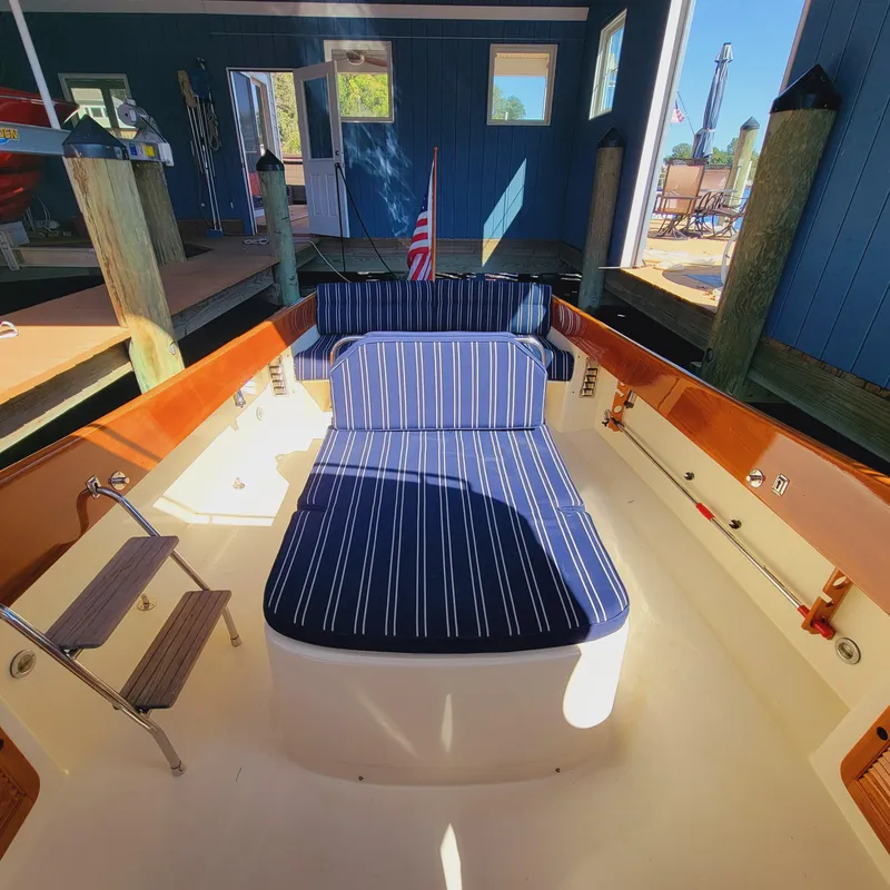 Slide: The Image of 1999 Hinckley Picnic Boat Classic with striped seating in a docked setting. - 45