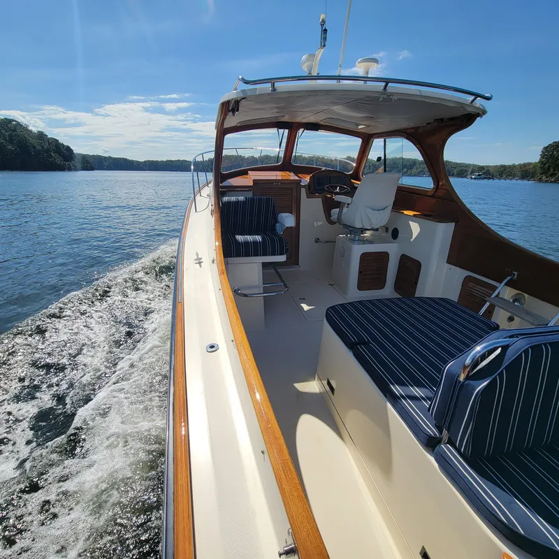 Slide: The Image of 1999 Hinckley Picnic Boat Classic cruising on a sunny day, featuring elegant interior and scenic water view. - 49