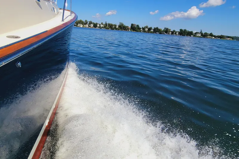 Slide: The Image of Hinckley Picnic Boat Classic 1999 cruising on a sunny lake with clear blue skies. - 5