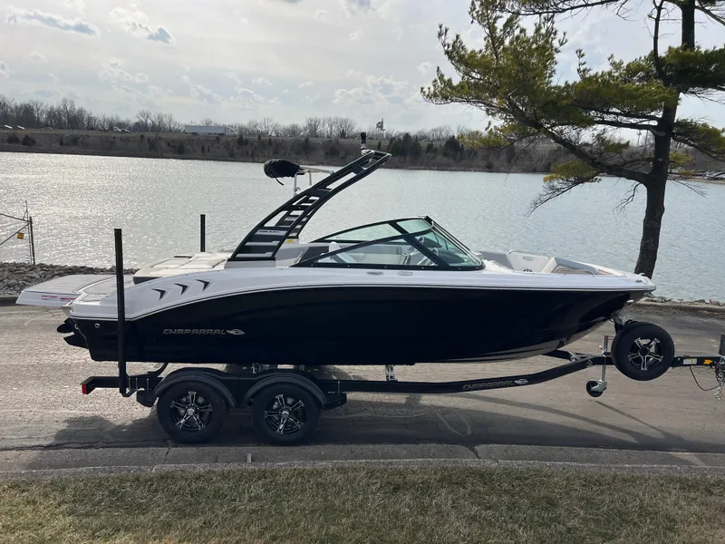Slide: The Image of 2025 Chaparral 21 SSi boat on trailer by a lake, side view. - 2