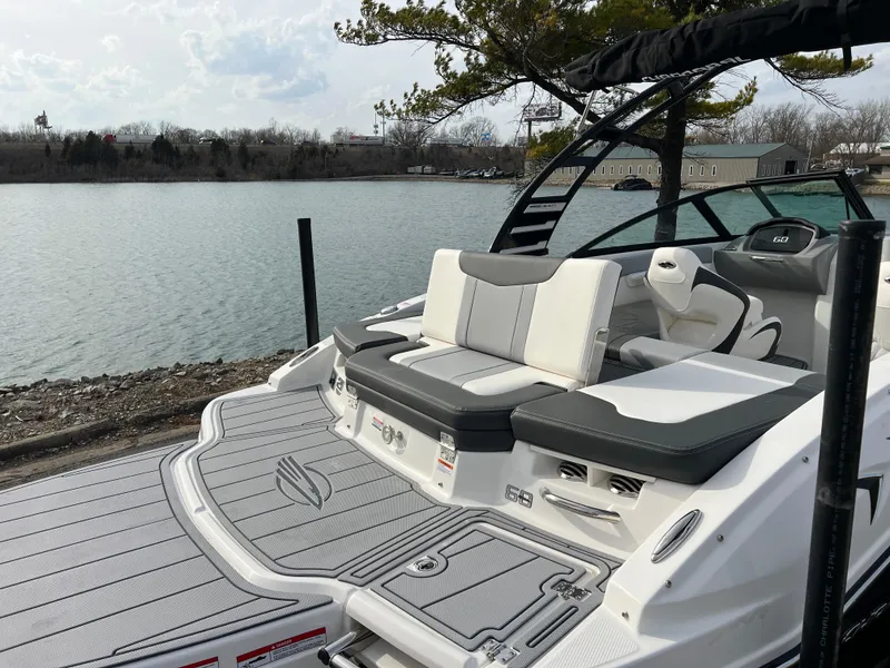 Slide: The Image of 2025 Chaparral 21 SSi boat with sleek seating, docked by a serene lake. - 5