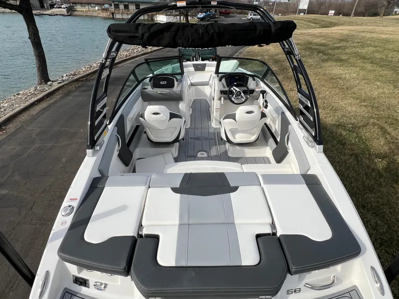 Slide: The Image of 2025 Chaparral 21 SSi boat interior, featuring sleek seating and modern design by the water. - 6
