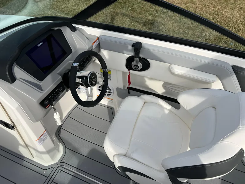 Slide: The Image of 2025 Chaparral 21 SSi boat interior with steering wheel and white captain's chair. - 8