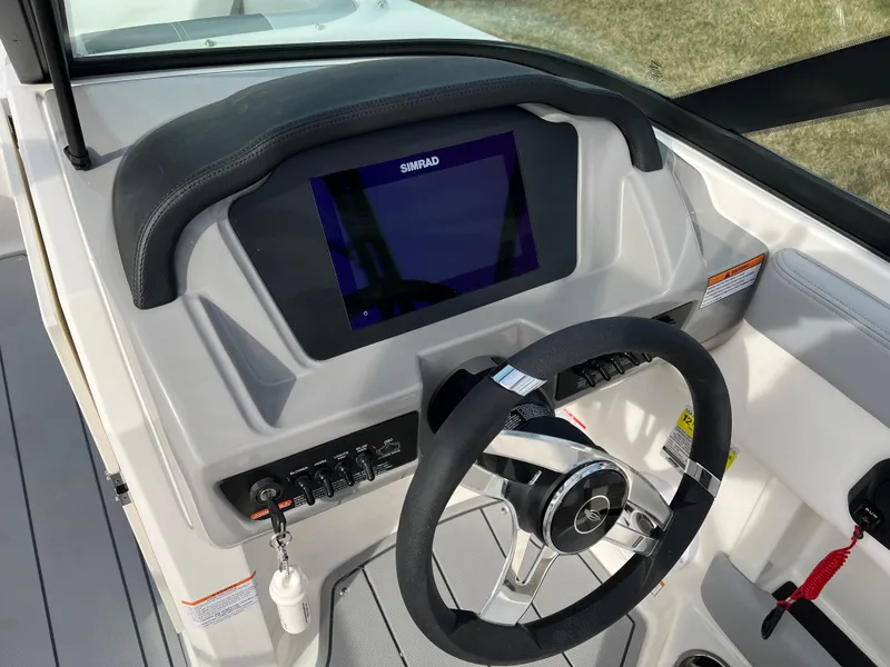 Slide: The Image of 2025 Chaparral 21 SSi boat dashboard with steering wheel and digital display. - 9