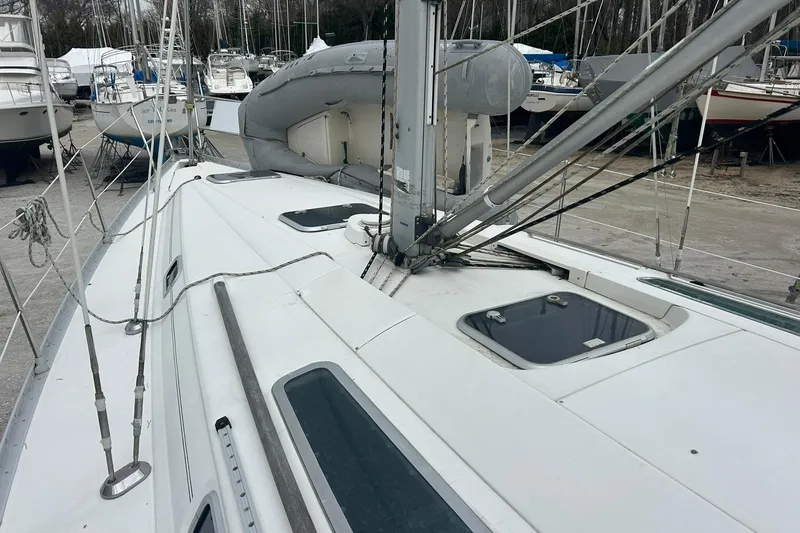 Slide: The Image of 1993 Beneteau Oceanis 400 sailboat deck with rigging and hatches in a marina. - 36