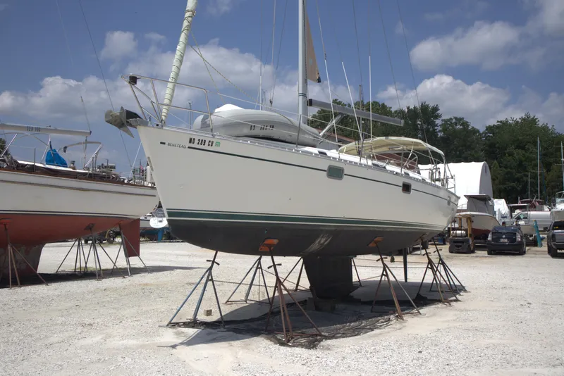 Slide: The Image of Beneteau Oceanis 400 sailboat from 1993 on stands in a boatyard under a blue sky. - 47
