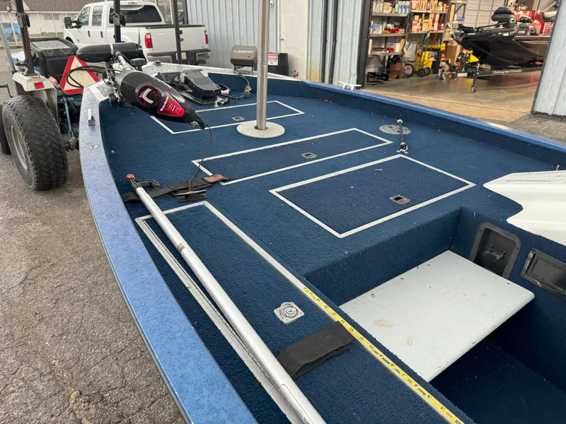 Slide: The Image of 1994 Lowe 170 boat with blue deck, fishing rod holders, and storage compartments. - 11