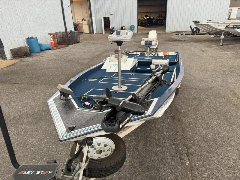 Slide: The Image of 1994 Lowe 170 boat on trailer in a marina parking lot. - 8