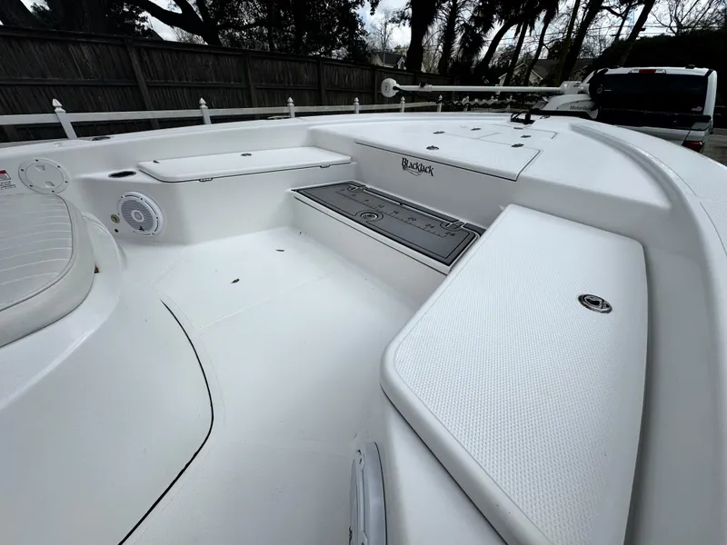 Slide: The Image of 2011 BlackJack 224 boat interior with white seating and storage compartments. - 15