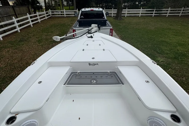 Slide: The Image of Bow view of 2011 BlackJack 224 boat hitched to a truck in a grassy yard. - 16