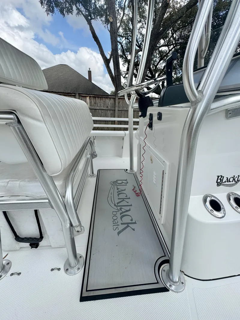 Slide: The Image of Interior view of a 2011 BlackJack 224 boat, featuring sleek seating and polished metal fixtures. - 20