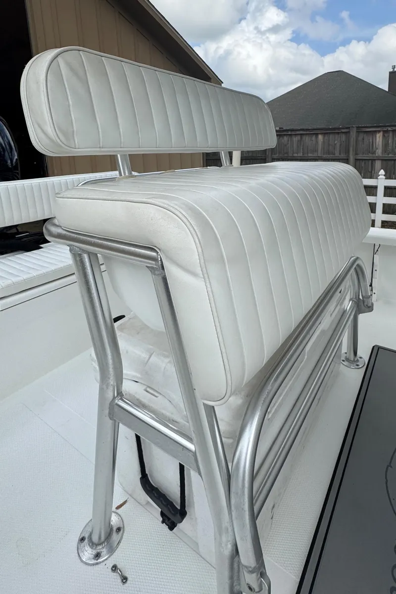 Slide: The Image of White cushioned boat seat on a 2011 BlackJack 224, featuring metal frame and outdoor setting. - 22