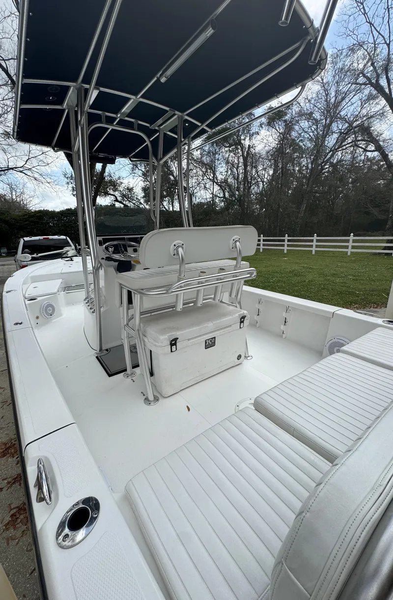 Slide: The Image of 2011 BlackJack 224 boat with T-top and seating, parked outdoors. - 27