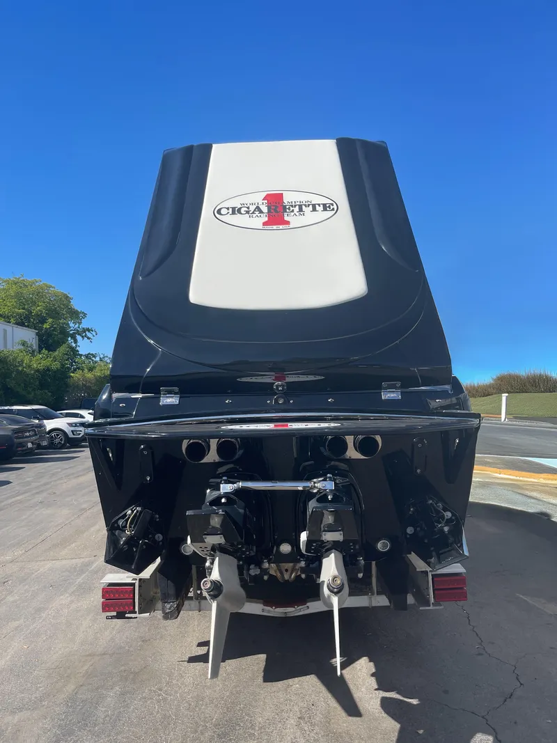 Slide: The Image of 2013 Cigarette 50' Marauder boat rear view with dual engines, parked outdoors. - 2